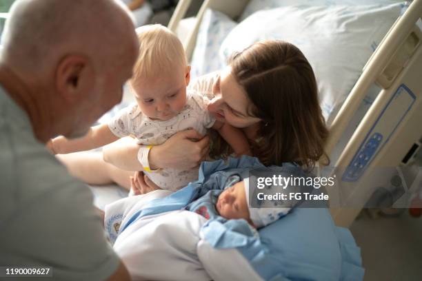 kleine kind jongen op zoek naar zijn pasgeboren broer in het ziekenhuis - hospital visit stockfoto's en -beelden