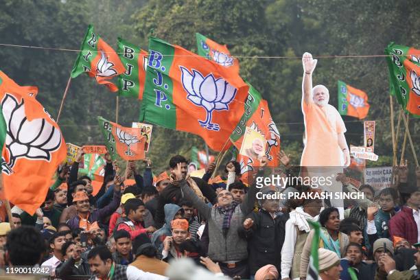 Cutout of India's Prime Minister Narendra Modi is held up as supporters of the Bharatiya Janata Party listen to his speech during a rally in New...