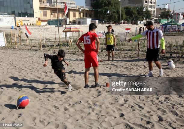 Iraqis play football as they wind down on the bank of the Tigris river in the capital Baghdad, on december 21, 2019. - In the heart of Baghdad, a few...