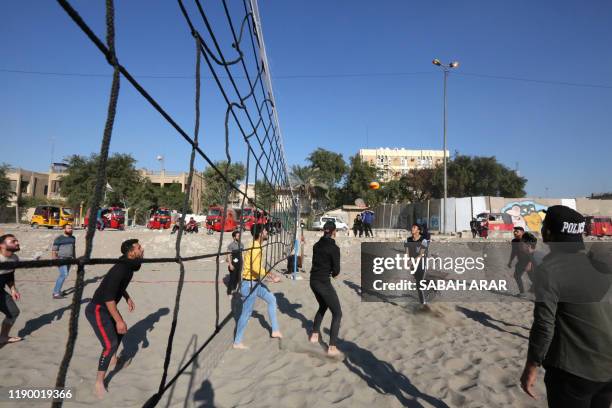 Iraqis play volleyball as they wind down on the bank of the Tigris river in the capital Baghdad, on december 21, 2019. - In the heart of Baghdad, a...