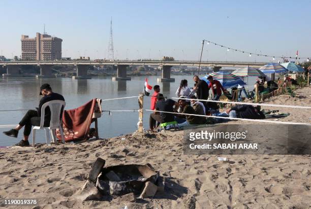 Iraqis wind down on the bank of the Tigris river in the capital Baghdad, on december 21, 2019. - In the heart of Baghdad, a few steps from the famed...