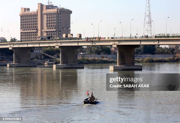 Members of the Iraqi military steer a boat in the waters of the Tigris river in the capital Baghdad, on december 21, 2019. - In the heart of Baghdad,...