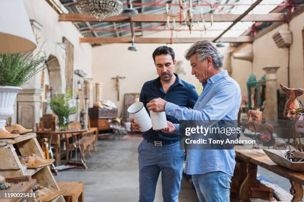 owner of antique shop talking with customer in his store - retail shop owner bildbanksfoton och bilder