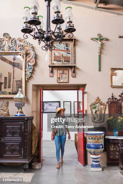woman wlaking through entrance of antique store - woman-looking-into-mirror-full-body stock pictures, royalty-free photos & images
