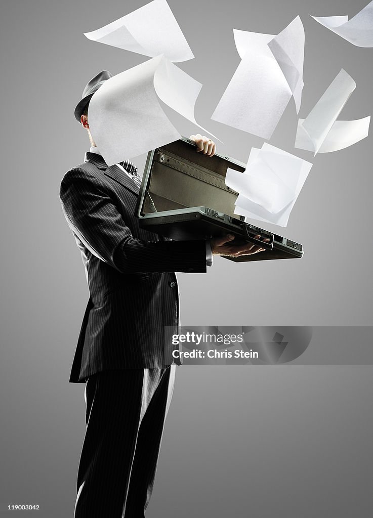 Business man holding and losing paper documents