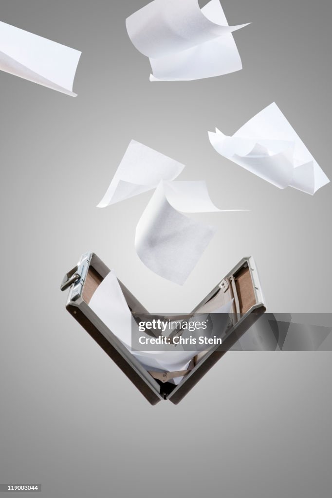Briefcase with paper flying out of it