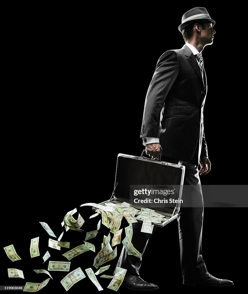 Business man losing money as he walks