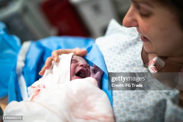 smiling mother holding her baby at hospital - caesarean section stock pictures, royalty-free photos & images