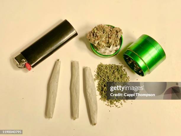 marijuana joints, ground cannabis, and grinder over white background - green lighter stock pictures, royalty-free photos & images