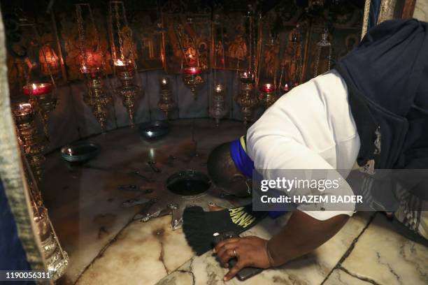 Pilgrim kisses the star in the Grotto of the Nativity at the eponymous Church, in the city of Bethlehem in the occupied West Bank, on December 22,...