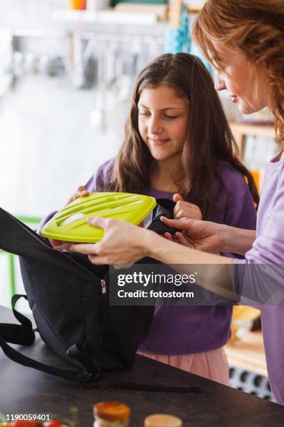 moeder en dochter verpakken lunch box in school rugzak - packing kids backpack stockfoto's en -beelden