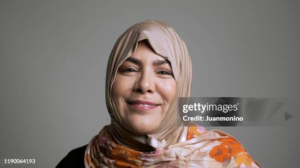 mature muslim woman looking at the camera - refugee portrait stock pictures, royalty-free photos & images