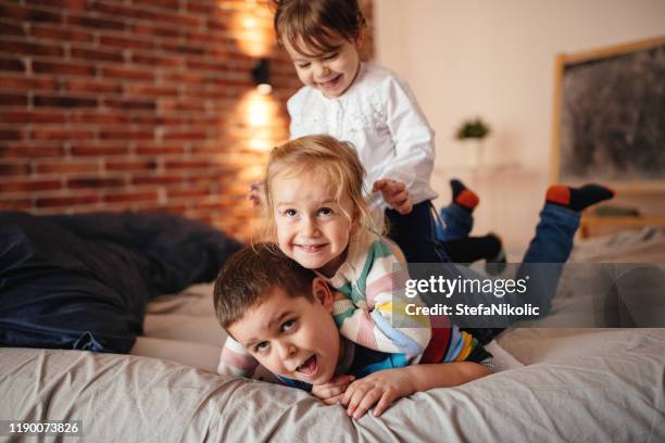 kinderen springen in bed - quirky family stockfoto's en -beelden