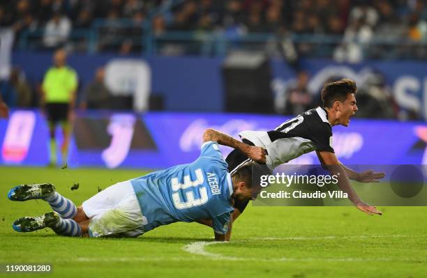 Paulo Dybala of Juventus falls after a challenge for the ball against Francesco Acerbi of SS Lazio during the Italian Supercup match between Juventus...