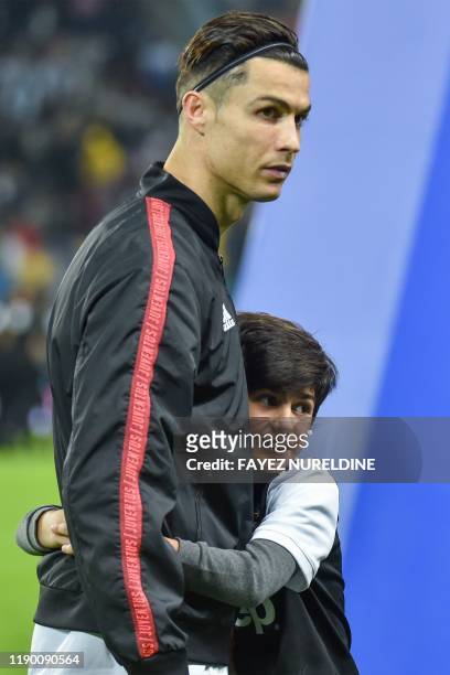 Young mascot hugs Juventus' Portuguese forward Cristiano Ronaldo during the Supercoppa Italiana final football match between Juventus and Lazio at...