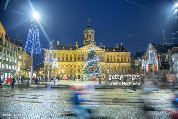 Night view of Dam Square or Damsquare with Christmas Tree decoration and lights in front of the illuminated Royal Palace or Koninklijk Paleis in...