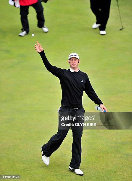 Golfer Dustin Johnson throws his ball as he reacts after his hole in one on the 16th, on the first day of the 140th British Open Golf championship at...