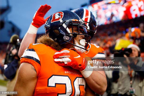 Running back Phillip Lindsay of the Denver Broncos is congratulated by a teammate after running for a fourth quarter touchdown against the Detroit...