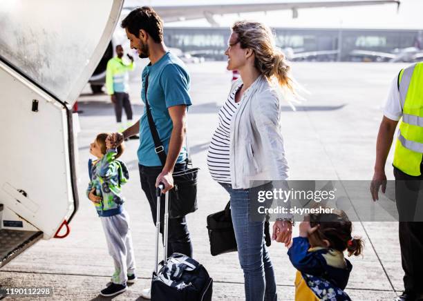happy family about to board in an airplane. - family airport stock pictures, royalty-free photos & images