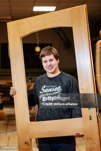 December 2019, Hessen, Aarbergen: Aaron Sauerborn, carpenter trainee, is standing in the workshop of the carpentry company "Holzbau Sven Krüger"....
