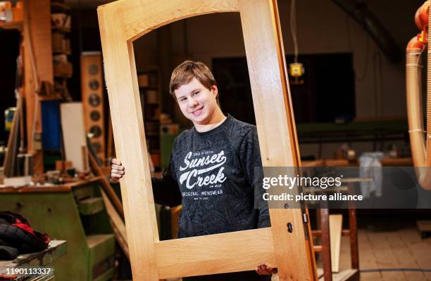 December 2019, Hessen, Aarbergen: Aaron Sauerborn, carpenter trainee, is standing in the workshop of the carpentry company "Holzbau Sven Krüger"....