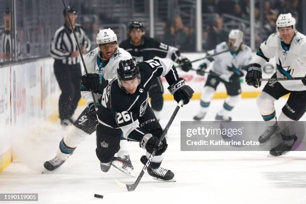 Evander Kane of the San Jose Sharks and Sean Walker of the Los Angeles Kings fight for control of the puck during a game at Staples Center on...