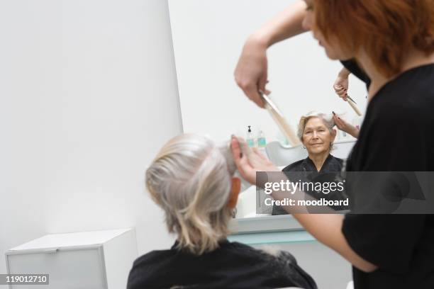stylist cuts elderly woman's hair - haar knippen stockfoto's en -beelden