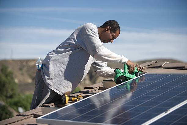 The 28 Most Profitable Small Business Ideas in Ethiopia 7 a man on a rooftop working on solar panelling
