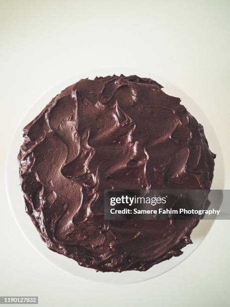 high angle view of a chocolate fudge cake on a display - fondant cakes stock-fotos und bilder