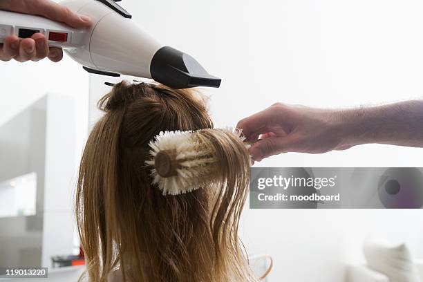 a young woman having her hair dried in the hairdressers - blow drying hair stock pictures, royalty-free photos & images