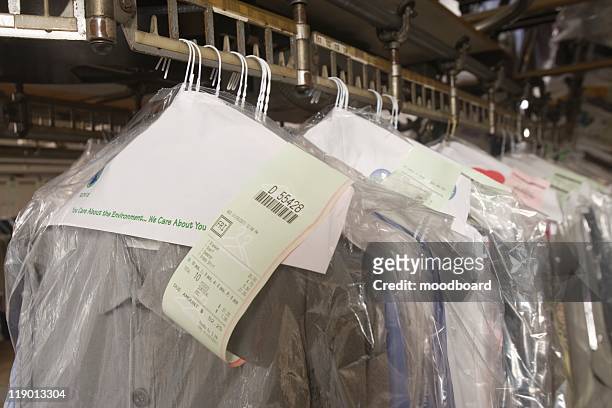 clothes hanging in the laundrette - dry cleaning shop stock pictures, royalty-free photos & images