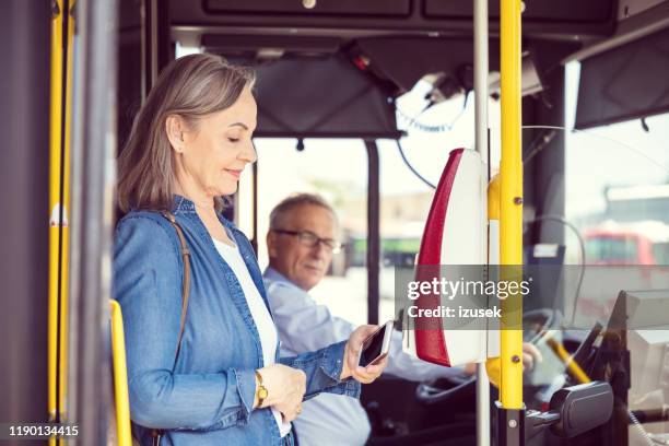 female passenger paying fare at entrance of bus - contactless payment bus stock pictures, royalty-free photos & images