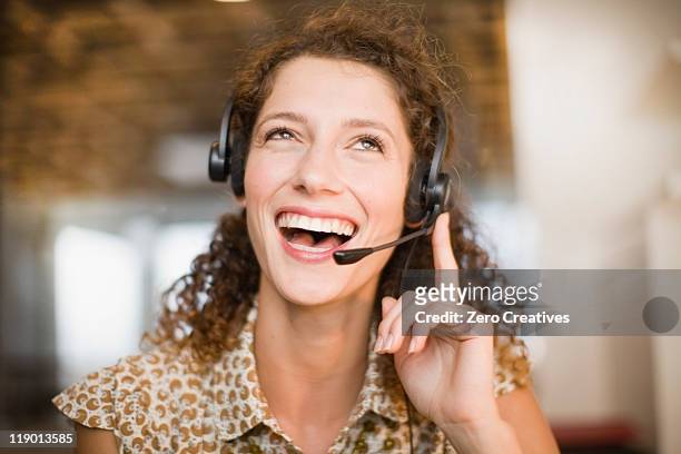 smiling woman wearing headset - answering stock pictures, royalty-free photos & images