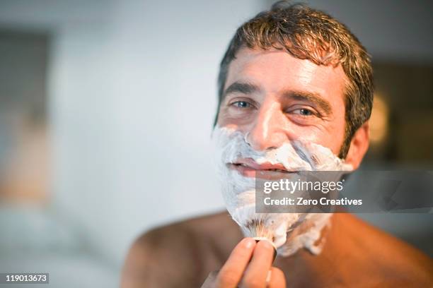 man lathering his face in bathroom - shaving brush stock-fotos und bilder