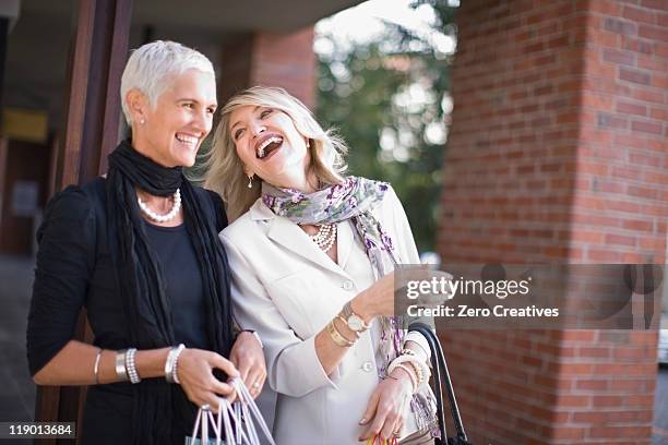 older women carrying shopping bags - luxury city break stock pictures, royalty-free photos & images