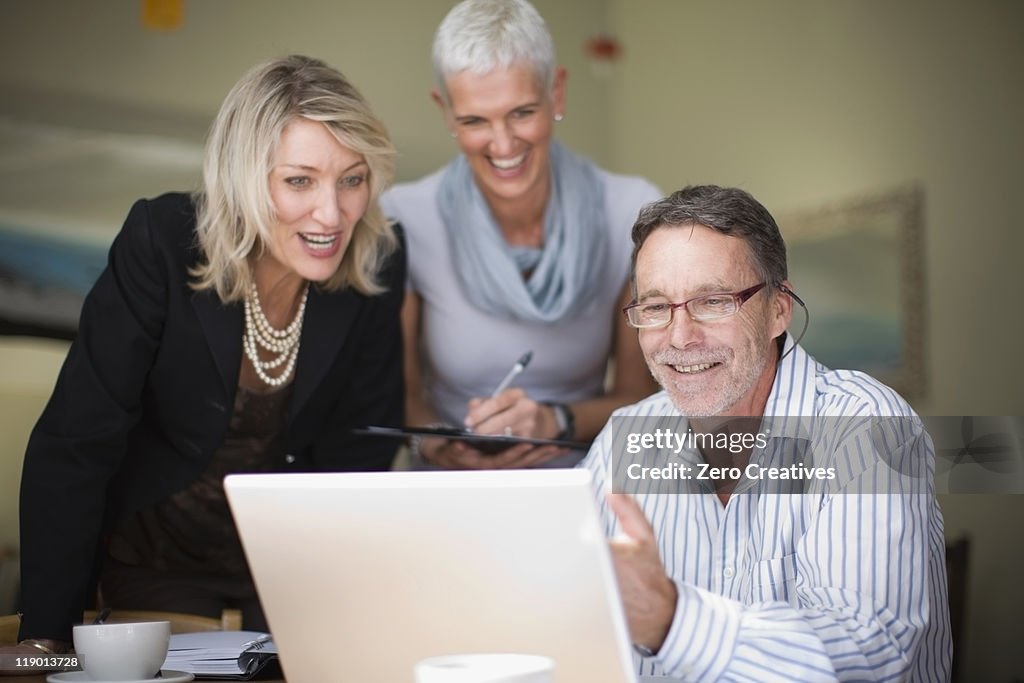 Businesspeople using laptop together
