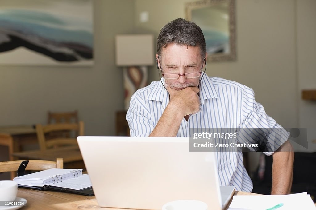 Serious businessman using laptop