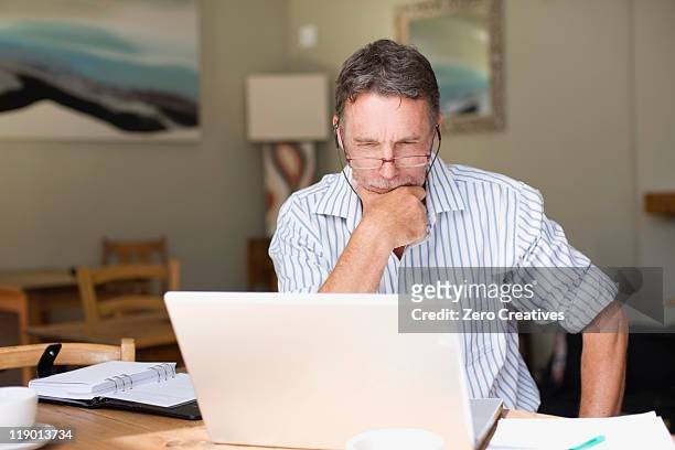 serious businessman using laptop - baby boomer stock pictures, royalty-free photos & images