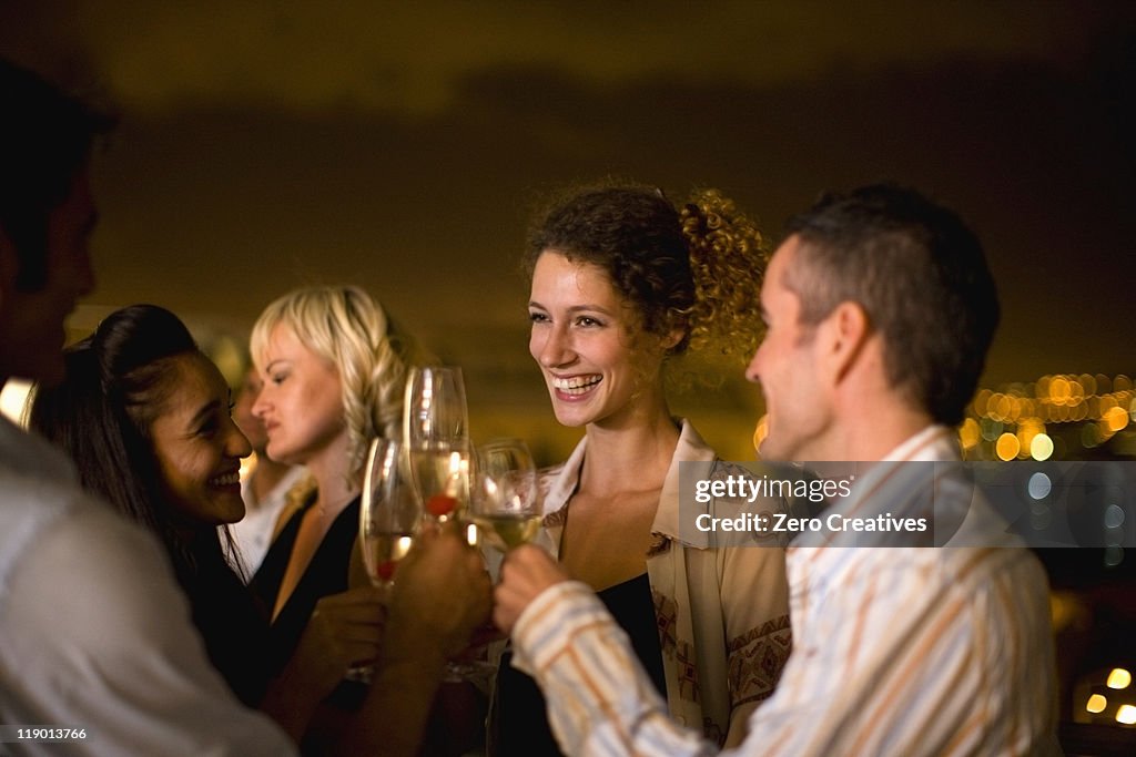 People having wine on terrace at night
