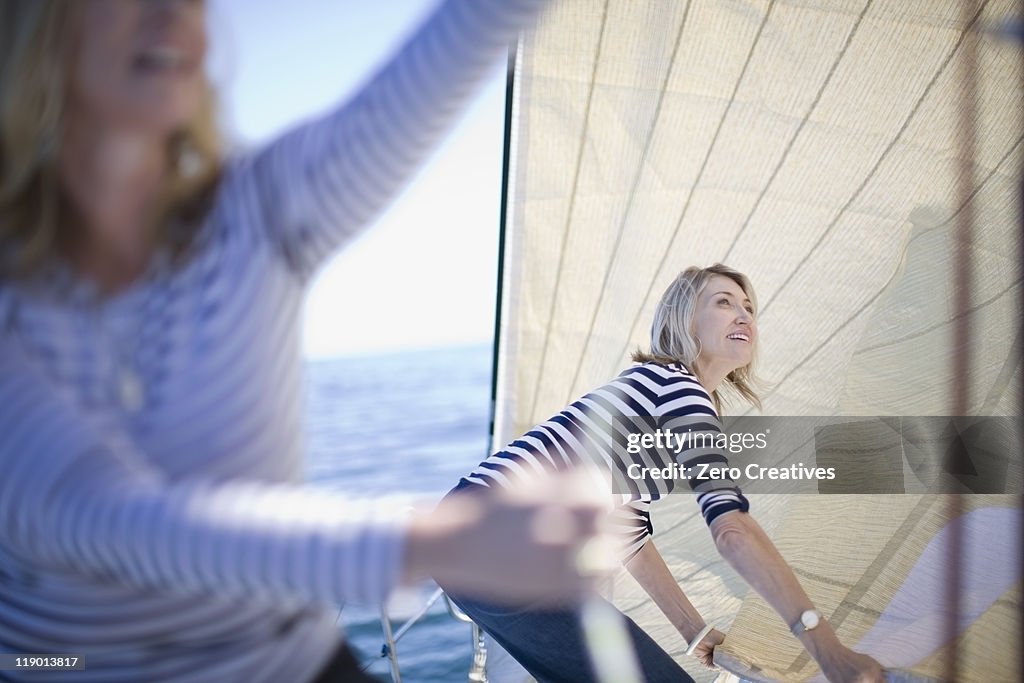 Women adjusting sails on boat