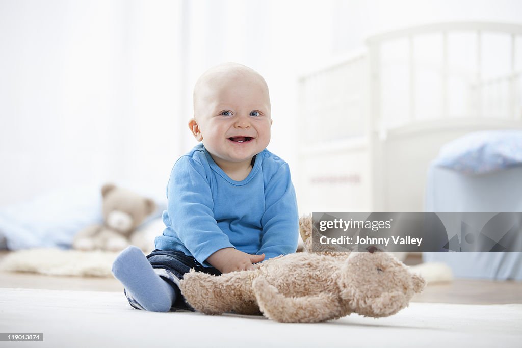 Baby boy playing with teddy bear