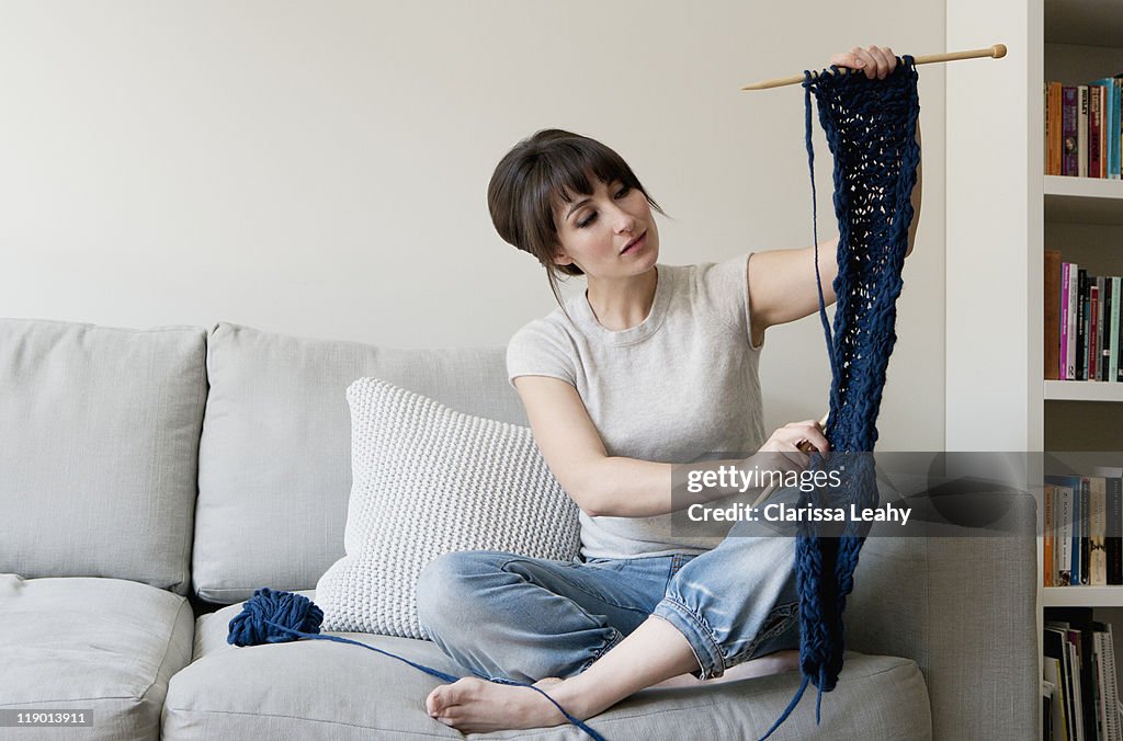 Woman examining knitting in living room