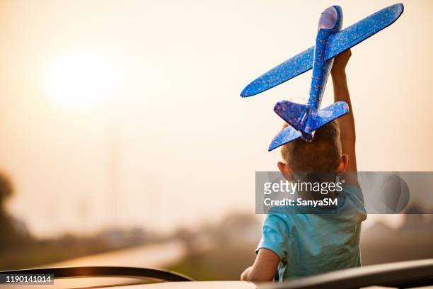jour rêvant d'un beau garçon avec le jouet d'avion vers le haut dans l'air - kid day dreaming photos et images de collection