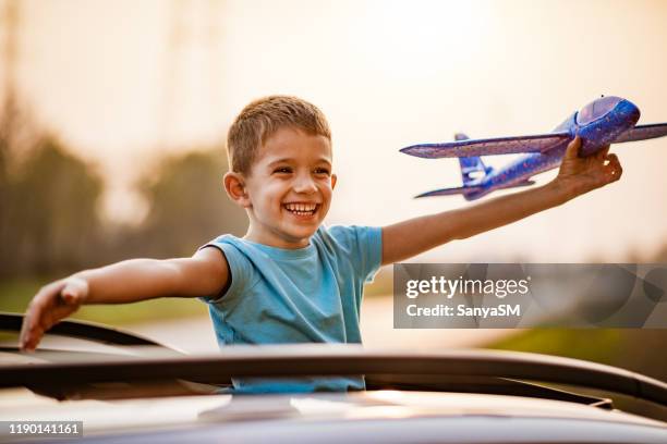 jour rêvant d'un beau garçon avec le jouet d'avion vers le haut dans l'air - kid day dreaming photos et images de collection