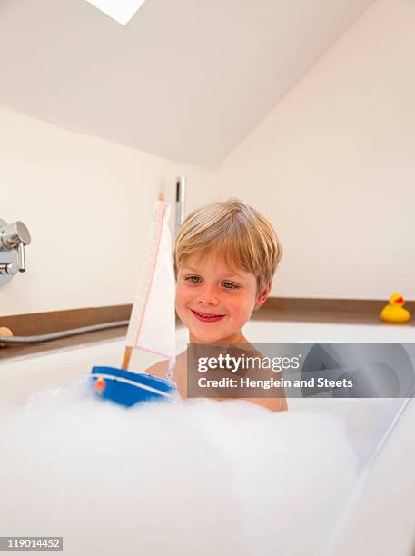 boy playing with sailboat in bath - boat in bath tub stock pictures, royalty-free photos & images