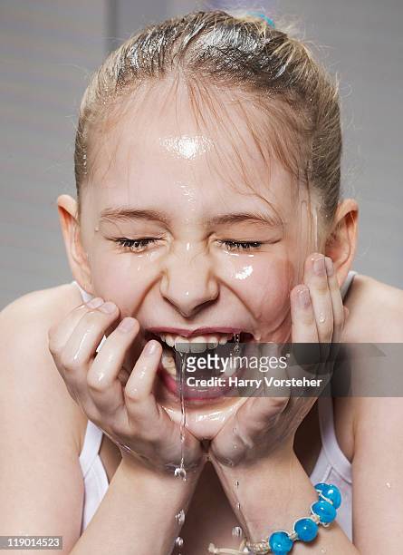 laughing girl washing her face - girls taking a showering stockfoto's en -beelden