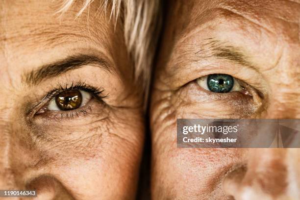 close up of senior couple looking at camera. - eye color stock pictures, royalty-free photos & images