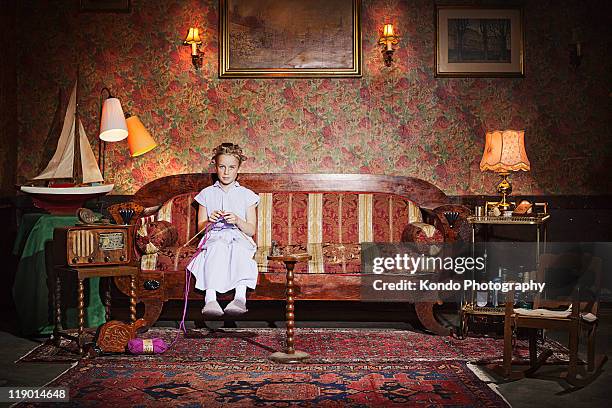 girl in rollers knitting - antique sofa styles foto e immagini stock