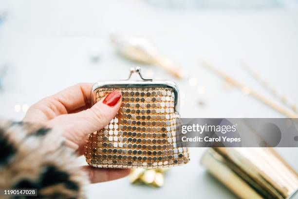 woman hand holding a golden walet - gold purse stock-fotos und bilder