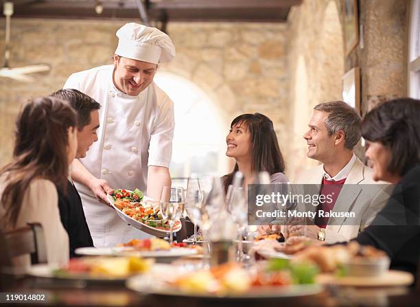 chef serving people in restaurant - indulged photos et images de collection